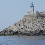 Il faro di capo Tenaro e la sua grigia pietraia visti dal mare